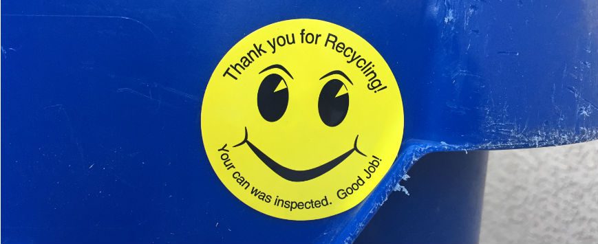 Smiley face on blue recycling can